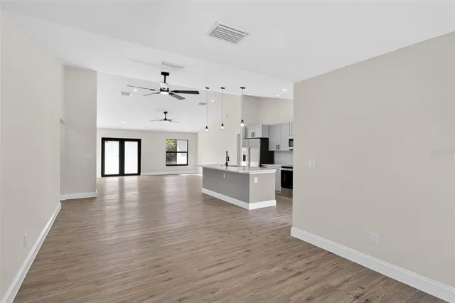 an empty room with a window and a ceiling fan