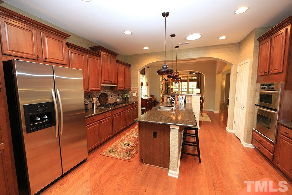 6003 Magenta Court Raleigh, NC 27617 - Photo 11 of 30 a kitchen with stainless steel appliances granite countertop a refrigerator a stove and a wooden floors