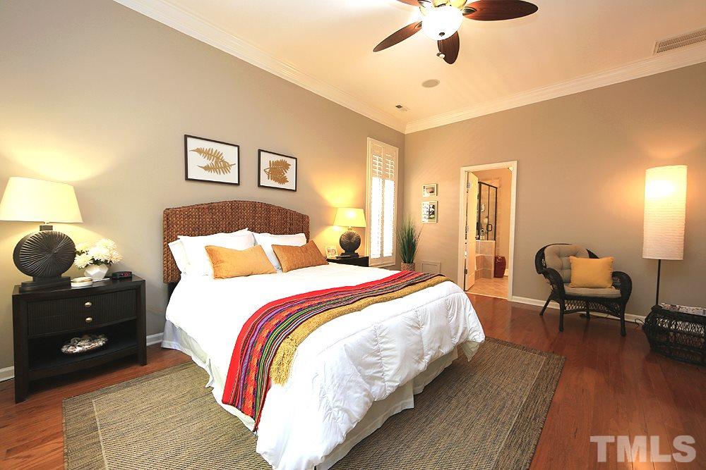 6003 Magenta Court Raleigh, NC 27617 - Photo 17 of 30 a bedroom with bed and a chandelier