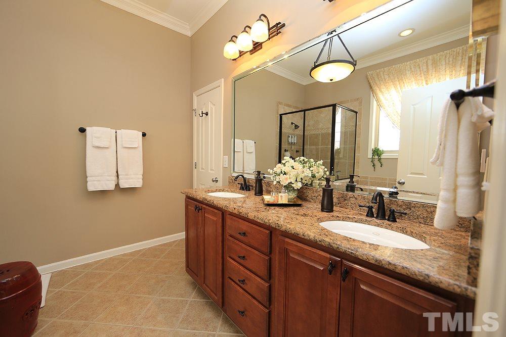 6003 Magenta Court Raleigh, NC 27617 - Photo 18 of 30 a bathroom with a granite countertop sink a large mirror and a shower