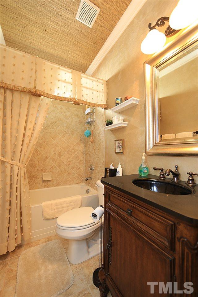 6003 Magenta Court Raleigh, NC 27617 - Photo 23 of 30 a bathroom with a granite countertop sink toilet a mirror and shower