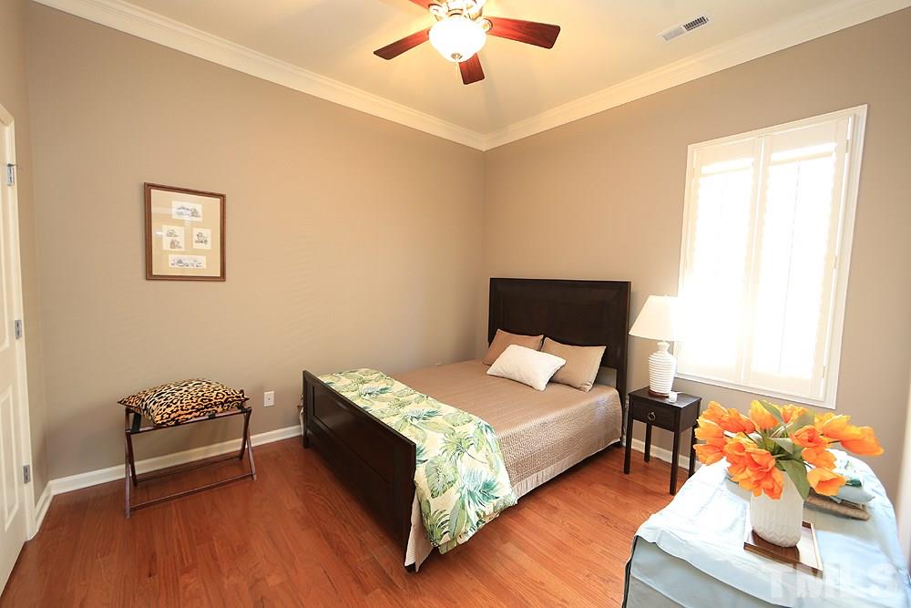 6003 Magenta Court Raleigh, NC 27617 - Photo 24 of 30 a bedroom with a bed and a chandelier