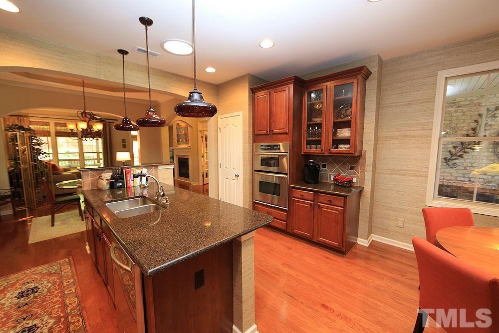 6003 Magenta Court Raleigh, NC 27617 - Photo 4 of 30 a kitchen with stainless steel appliances granite countertop a sink a stove and a wooden floors