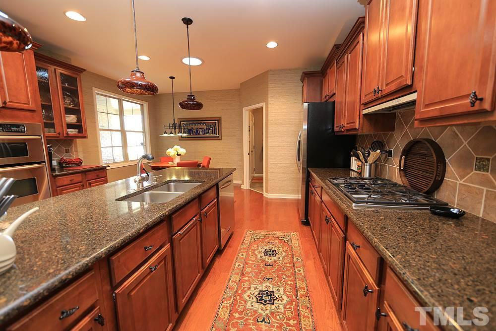 6003 Magenta Court Raleigh, NC 27617 - Photo 6 of 30 a kitchen with stainless steel appliances granite countertop a stove a sink and a refrigerator