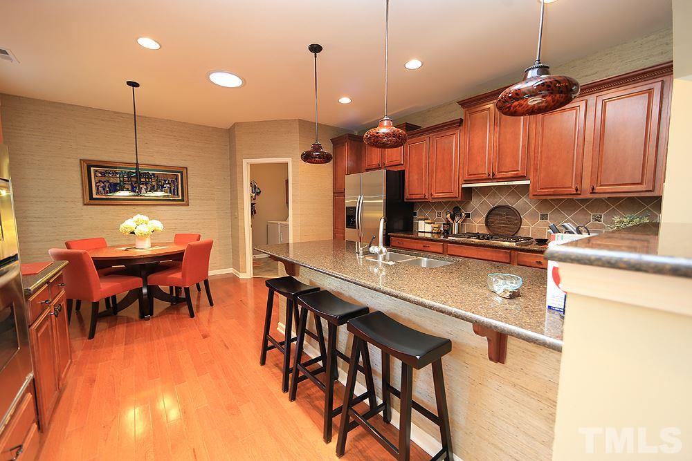 6003 Magenta Court Raleigh, NC 27617 - Photo 9 of 30 a kitchen with stainless steel appliances kitchen island granite countertop a table chairs and a refrigerator