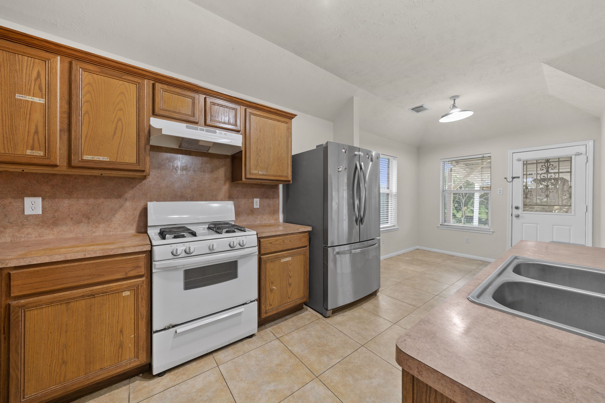 10330 Turrett Point Lane Houston, TX 77064 - Photo 5 of 15 a kitchen with stainless steel appliances granite countertop a refrigerator a stove and a sink