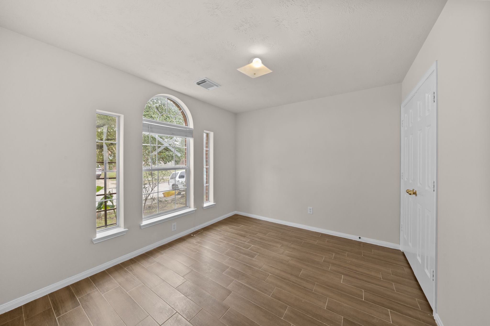 10330 Turrett Point Lane Houston, TX 77064 - Photo 10 of 15 an empty room with wooden floor and windows