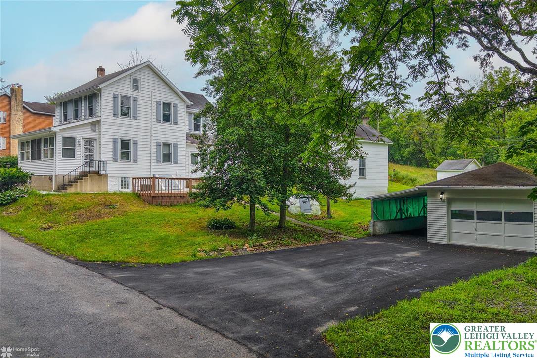a front view of a house with a yard and trees