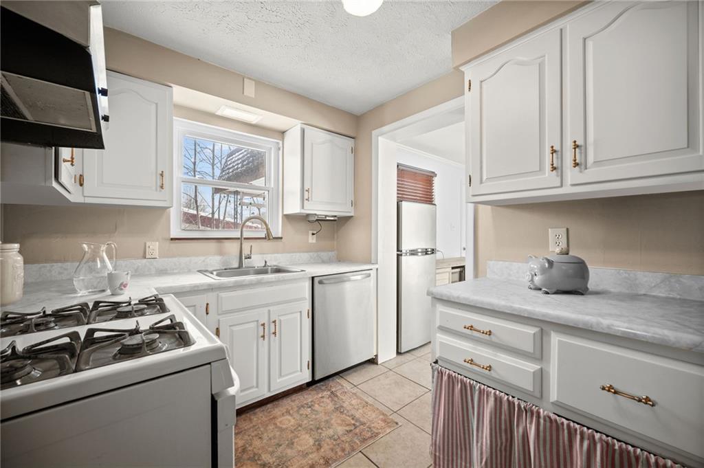 2079 Spring Valley Road Pittsburgh, PA 15243 - Photo 11 of 35 a kitchen with white cabinets and white appliances