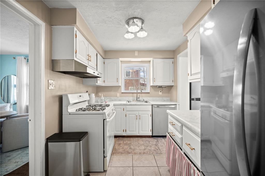 2079 Spring Valley Road Pittsburgh, PA 15243 - Photo 15 of 35 a kitchen with a sink cabinets stainless steel appliances and a window
