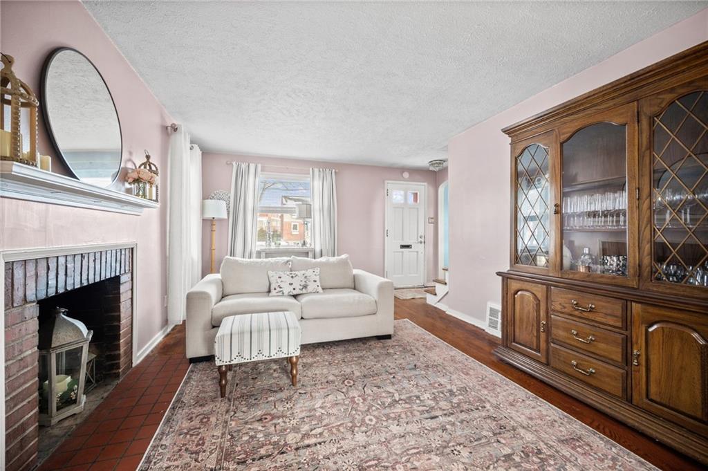 2079 Spring Valley Road Pittsburgh, PA 15243 - Photo 5 of 35 a living room with furniture a fireplace and a rug