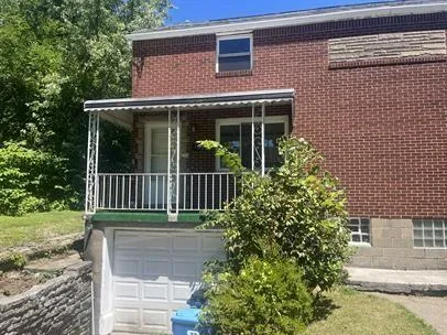 a view of a house with a small yard plants and large tree