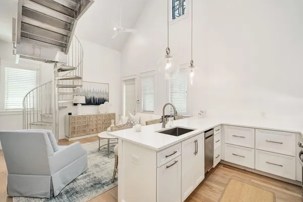 a kitchen with white cabinets and sink