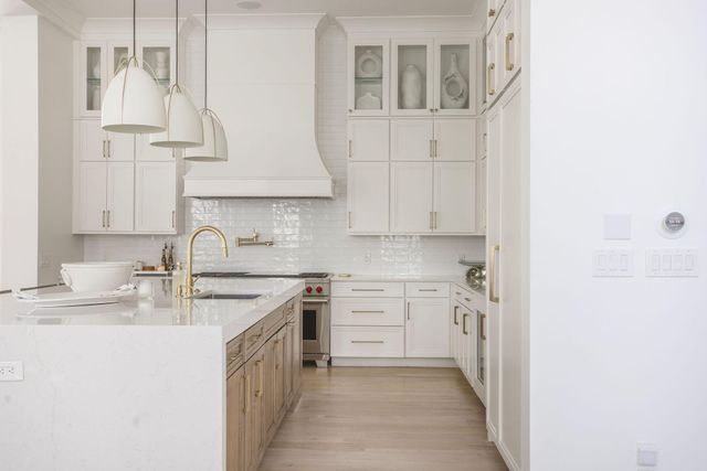 a kitchen with stainless steel appliances granite countertop a sink stove and cabinets
