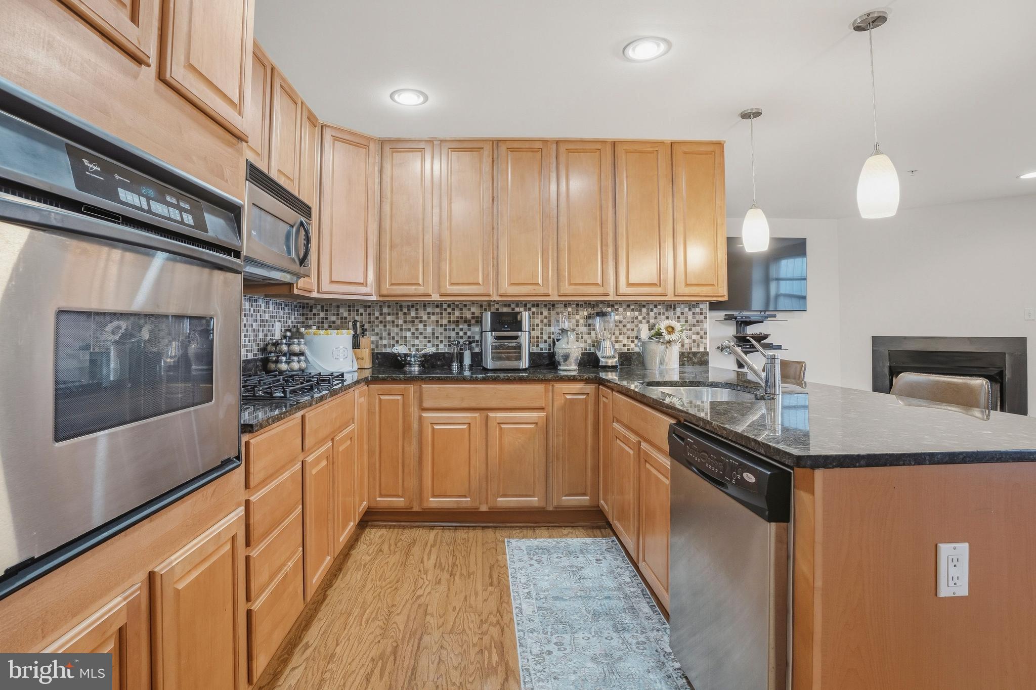 9500 Sidebrook Road, Unit 406 Owings Mills, MD 21117 - Photo 13 of 35 a kitchen with stainless steel appliances granite countertop a sink stove and cabinets