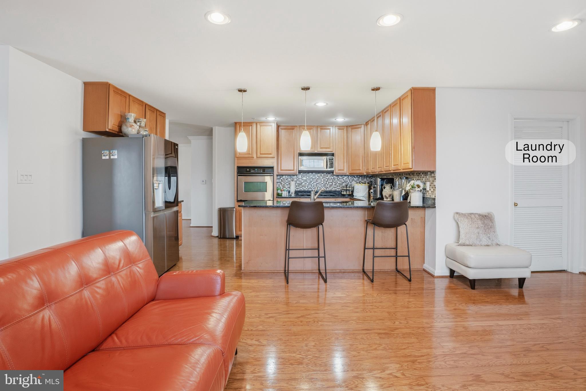 9500 Sidebrook Road, Unit 406 Owings Mills, MD 21117 - Photo 17 of 35 a living room with furniture and a kitchen appliance view