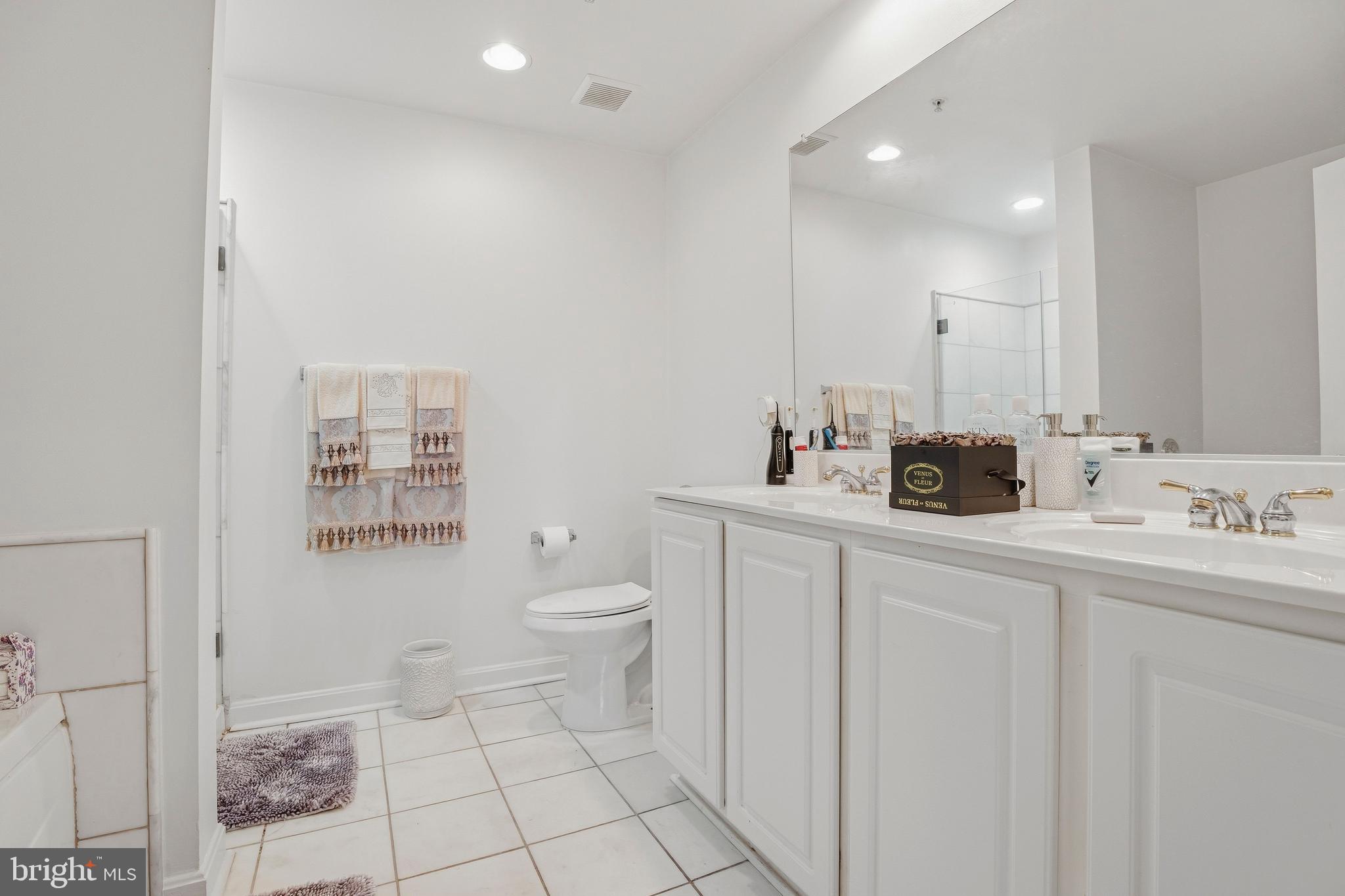 9500 Sidebrook Road, Unit 406 Owings Mills, MD 21117 - Photo 26 of 35 a bathroom with a toilet sink and mirror
