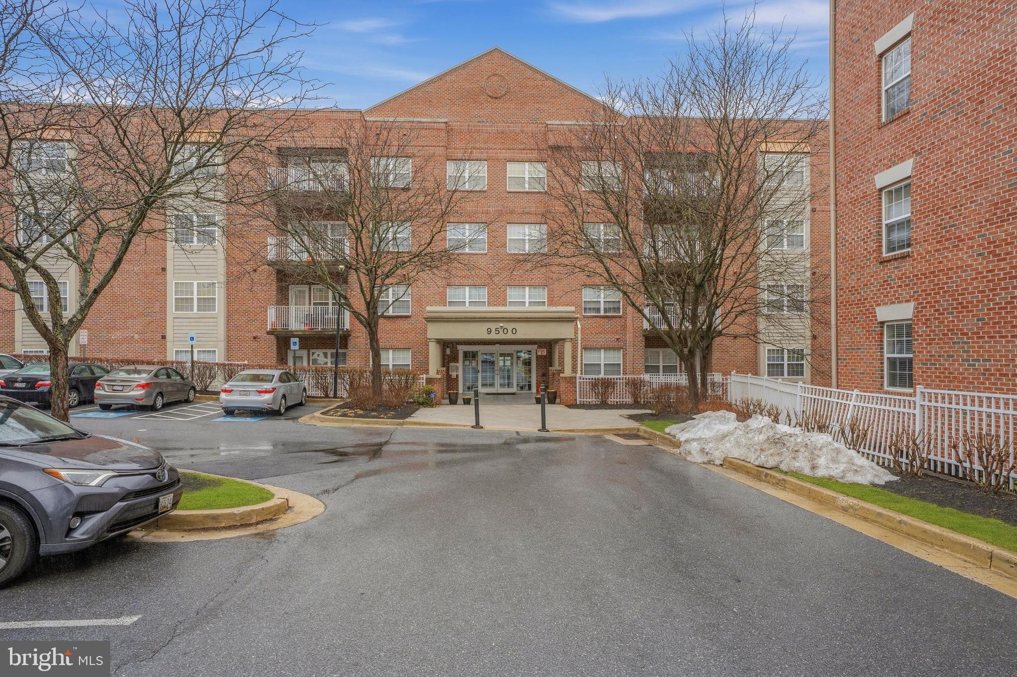 9500 Sidebrook Road, Unit 406 Owings Mills, MD 21117 - Photo 29 of 35 a front view of a building with lot of cars parked on road