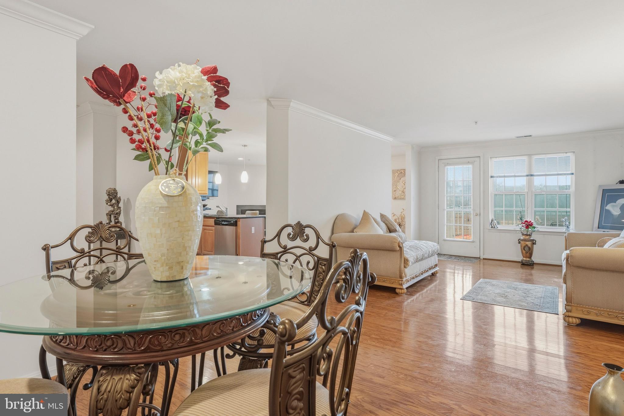 9500 Sidebrook Road, Unit 406 Owings Mills, MD 21117 - Photo 35 of 35 a dining room with furniture potted plants and wooden floor