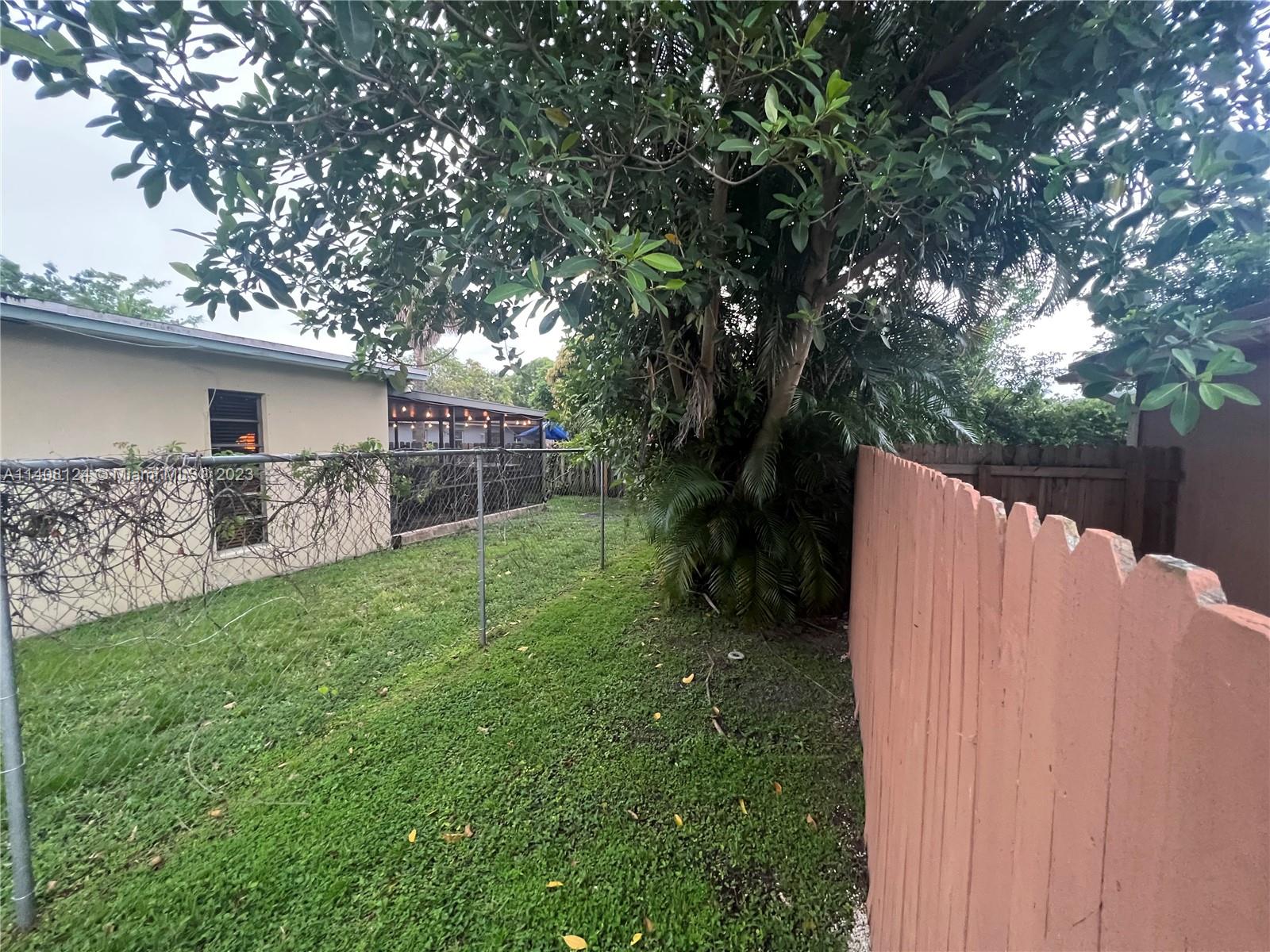 5507 Southwest 7th Court Margate, FL 33068 - Photo 20 of 21 a view of a backyard with a tree and wooden fence
