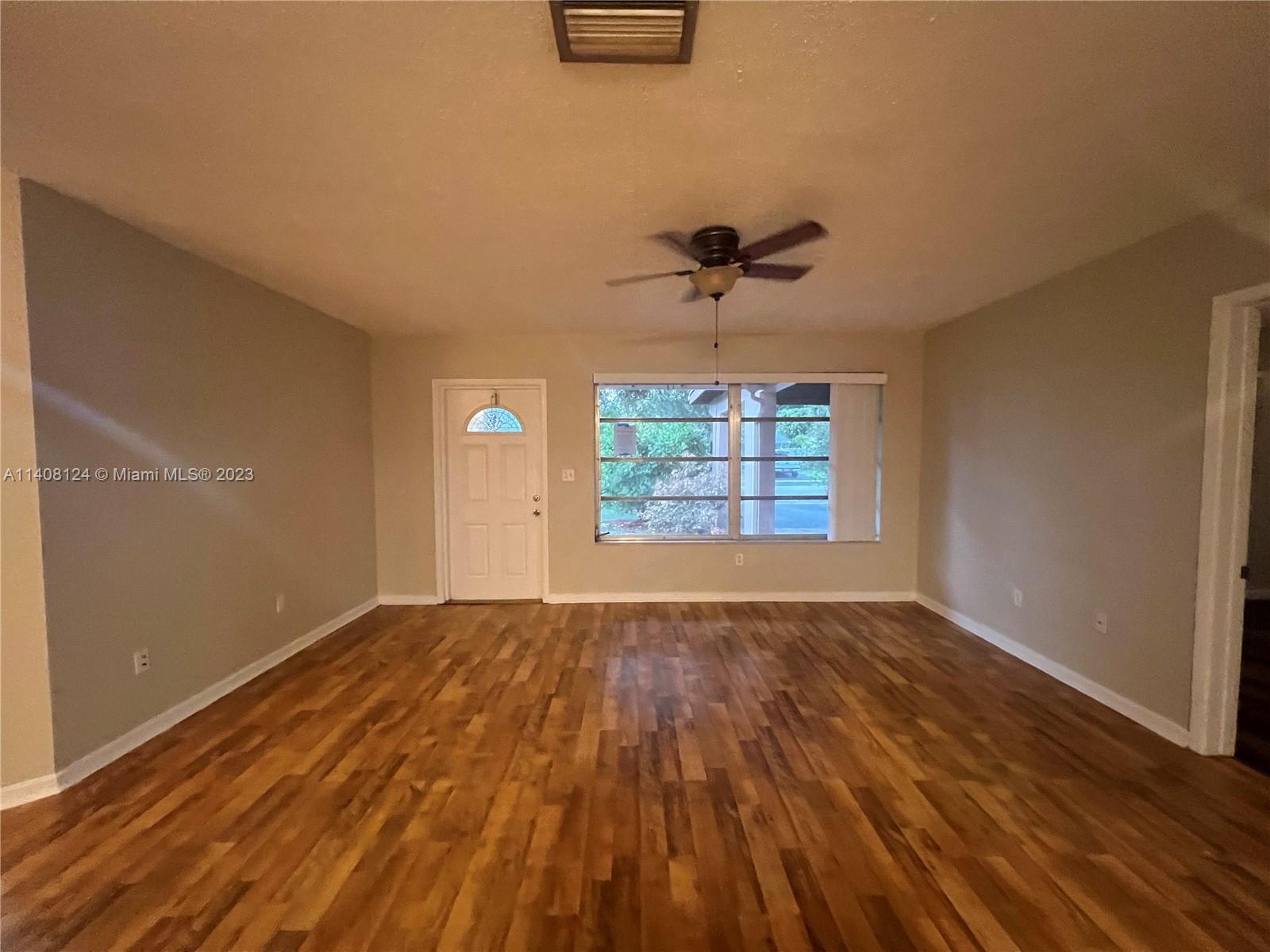 5507 Southwest 7th Court Margate, FL 33068 - Photo 4 of 21 wooden floor in an empty room with a window
