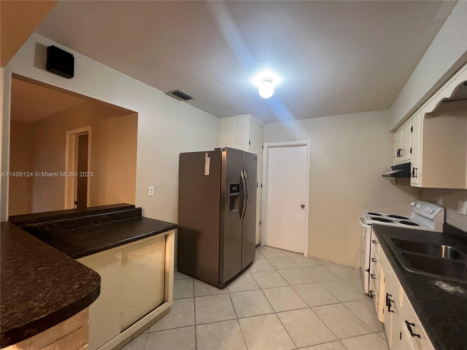 5507 Southwest 7th Court Margate, FL 33068 - Photo 7 of 21 a kitchen with a refrigerator and a stove top oven