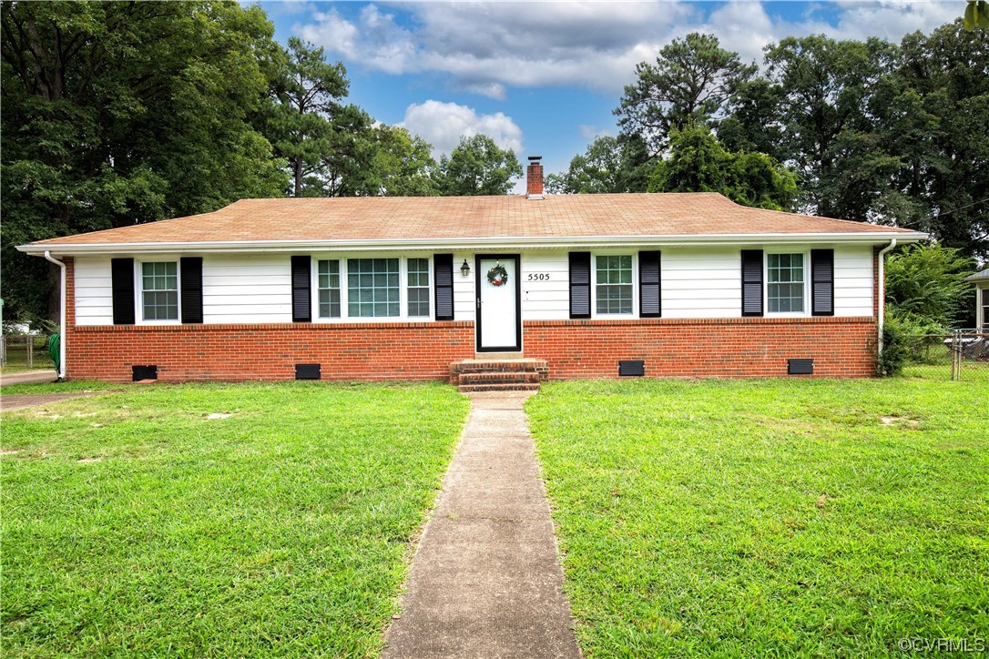 a front view of a house with a yard and garden