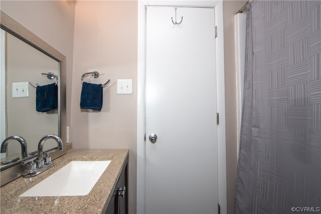 5505 Raleigh Road Henrico, VA 23231 - Photo 13 of 30 a bathroom with a granite countertop sink and a mirror