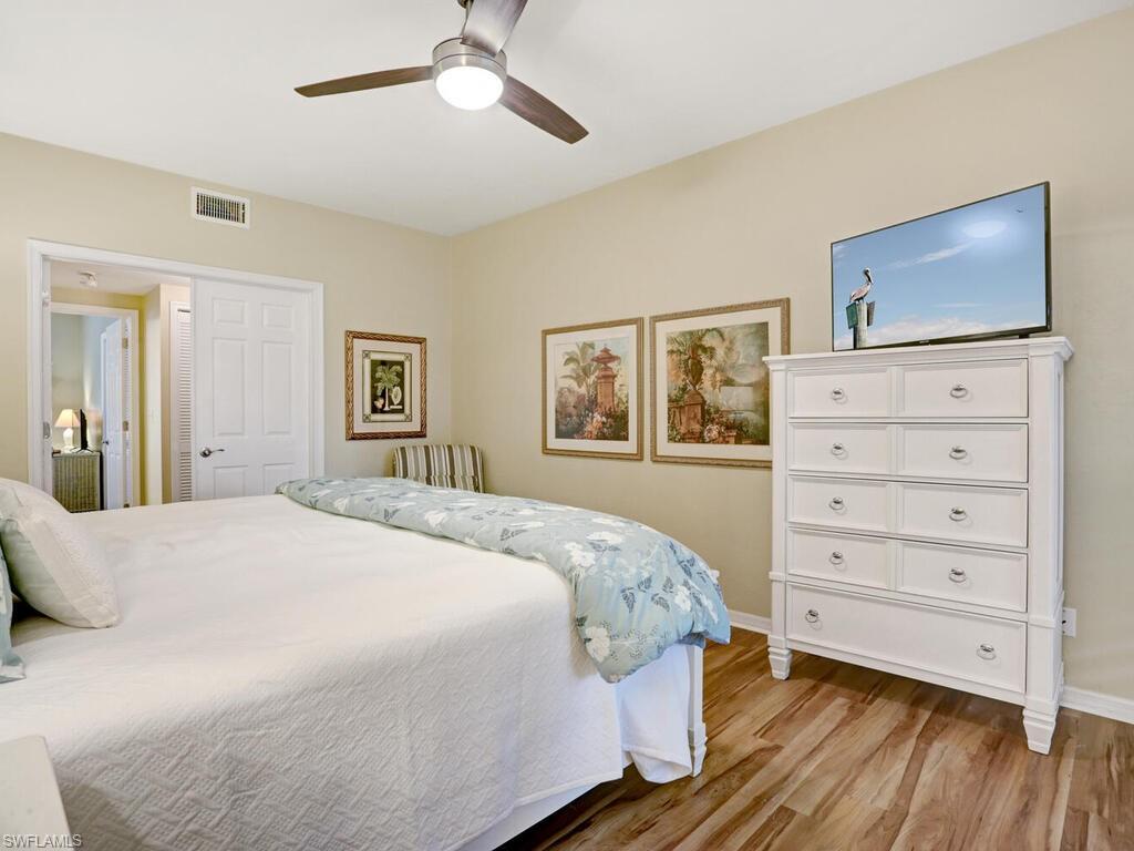352 Bay Forest Drive, Unit 103 Naples, FL 34110 - Photo 15 of 30 a bedroom with a bed and a flat screen tv