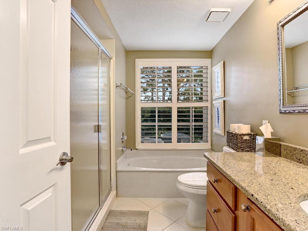 352 Bay Forest Drive, Unit 103 Naples, FL 34110 - Photo 19 of 30 a bathroom with a granite countertop sink a toilet and shower