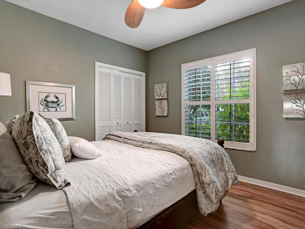 352 Bay Forest Drive, Unit 103 Naples, FL 34110 - Photo 22 of 30 a bedroom with a bed and wooden floor