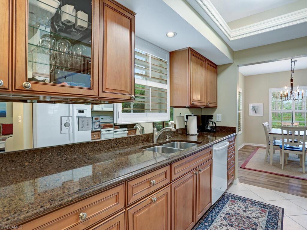 352 Bay Forest Drive, Unit 103 Naples, FL 34110 - Photo 9 of 30 a kitchen with stainless steel appliances granite countertop wooden cabinets a sink and dishwasher