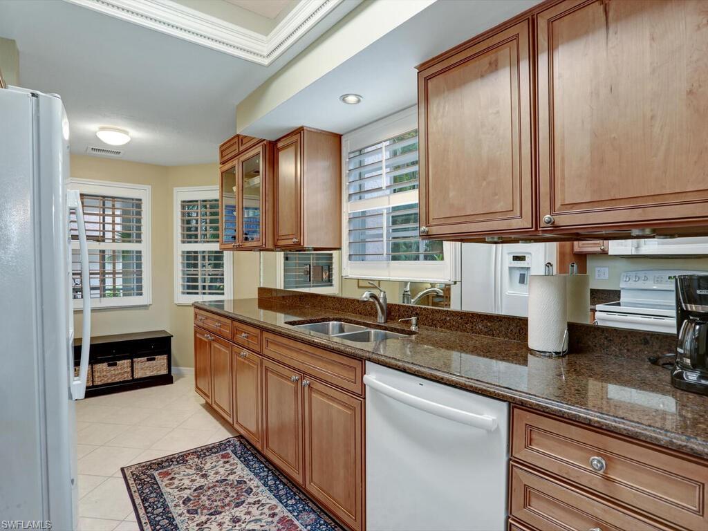 352 Bay Forest Drive, Unit 103 Naples, FL 34110 - Photo 10 of 30 a kitchen with stainless steel appliances granite countertop a sink stove and cabinets