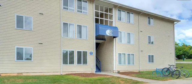 a view of a house with a yard and lawn chairs