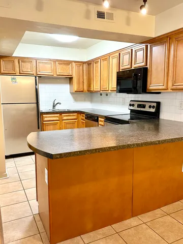 a kitchen with stainless steel appliances granite countertop a sink a stove counter space and cabinets