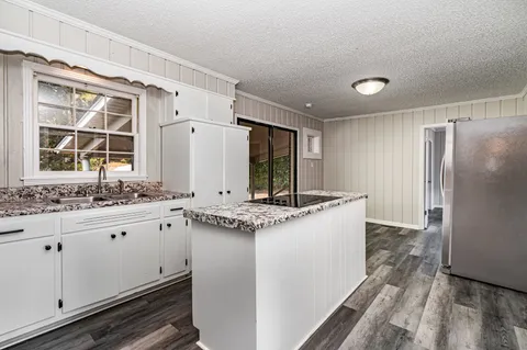 a kitchen with granite countertop a sink and cabinets