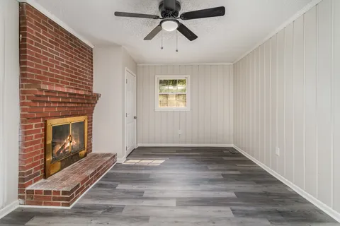 a view of an empty room with window and fire place