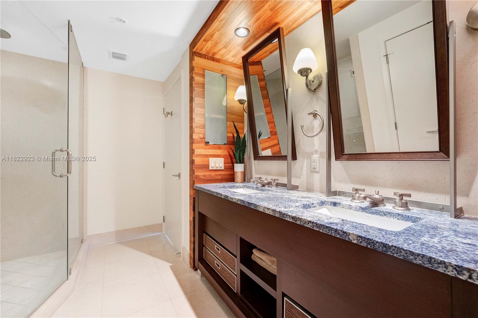 6899 Collins Avenue, Unit 1409 Miami Beach, FL 33141 - Photo 28 of 35 a bathroom with a granite countertop double vanity sink and mirror