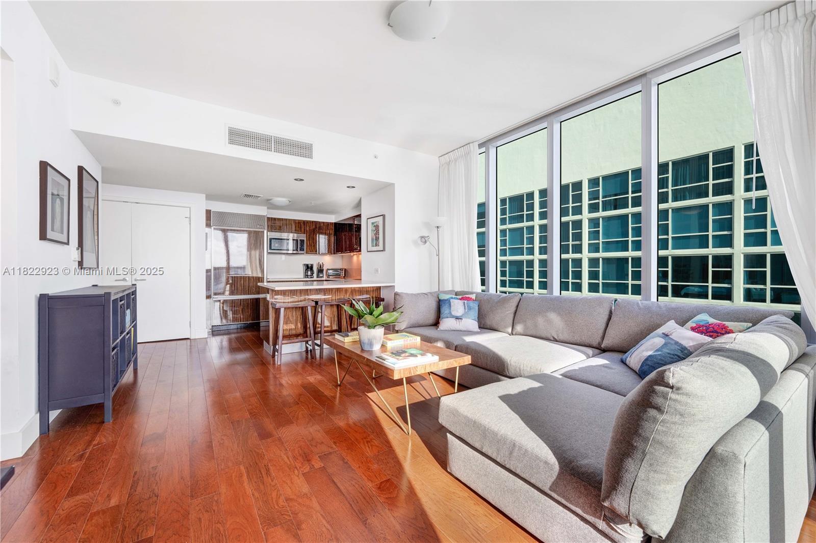 6899 Collins Avenue, Unit 1409 Miami Beach, FL 33141 - Photo 10 of 35 a living room with furniture and floor to ceiling windows