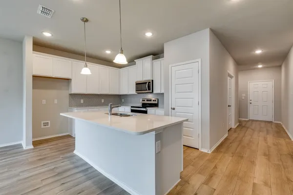 a view of kitchen with sink microwave and refrigerator