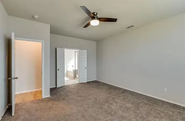 an empty room with closet and windows