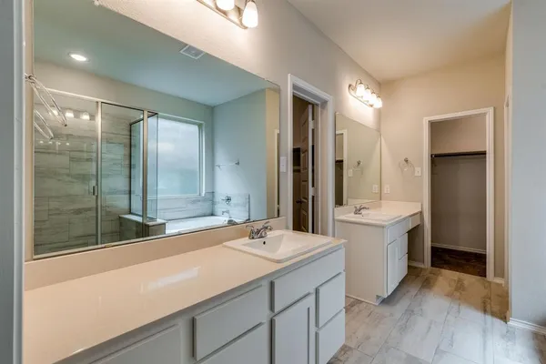 a bathroom with a double vanity sink a mirror and a bathtub