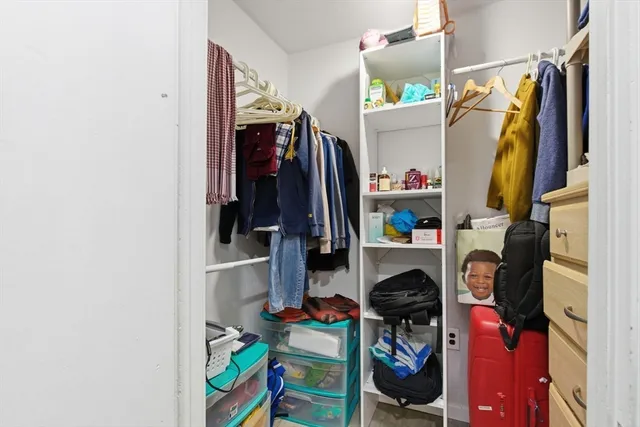 a view of walk in closet with clothes and shoes