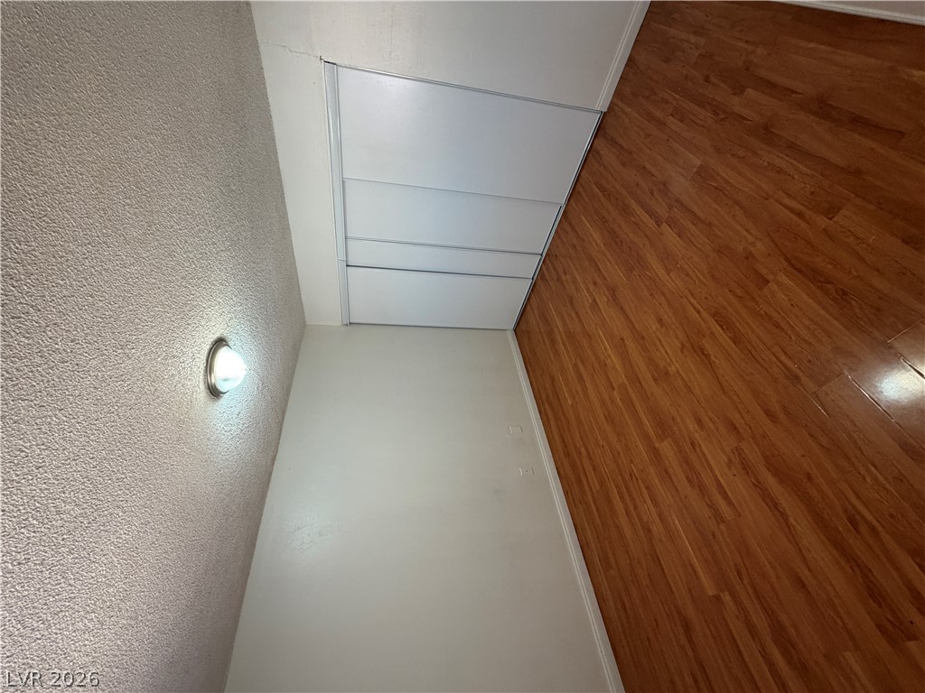 2236 East Desert Inn Road Las Vegas, NV 89169 - Photo 16 of 34 Rich hardwood-style flooring extends toward a discreet access panel, maximizing every inch of living space.