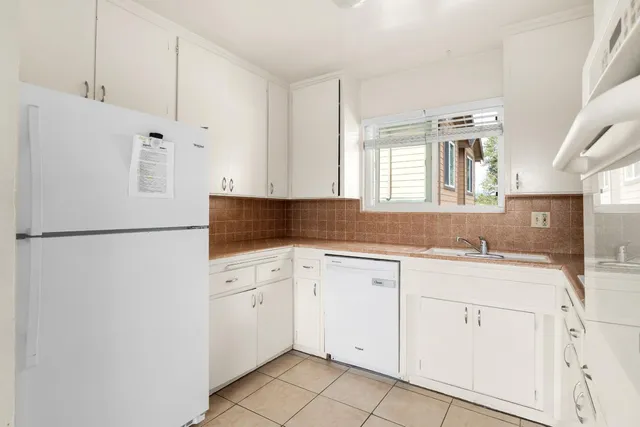 a kitchen with a refrigerator sink and cabinets