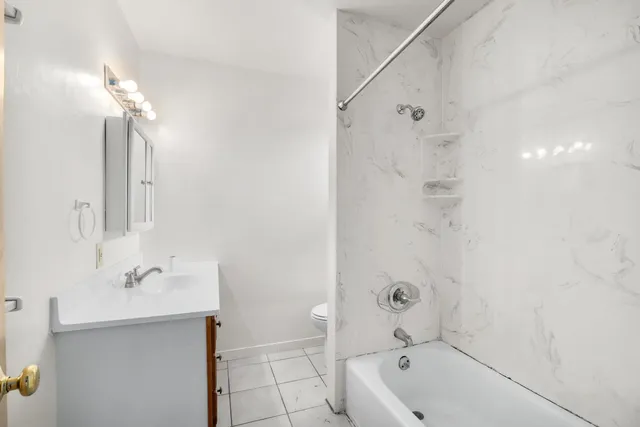 a bathroom with a tub a sink and mirror