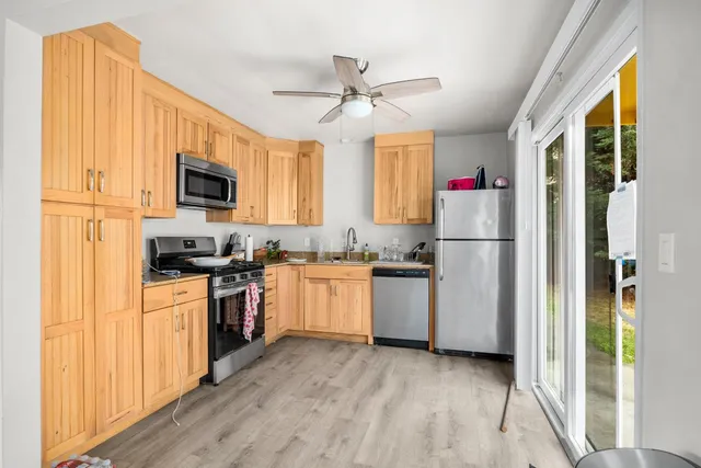 a kitchen with refrigerator cabinets and window