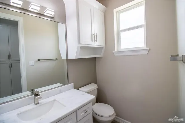 a bathroom with a sink a toilet and a window