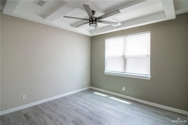 an empty room with a window and a ceiling fan
