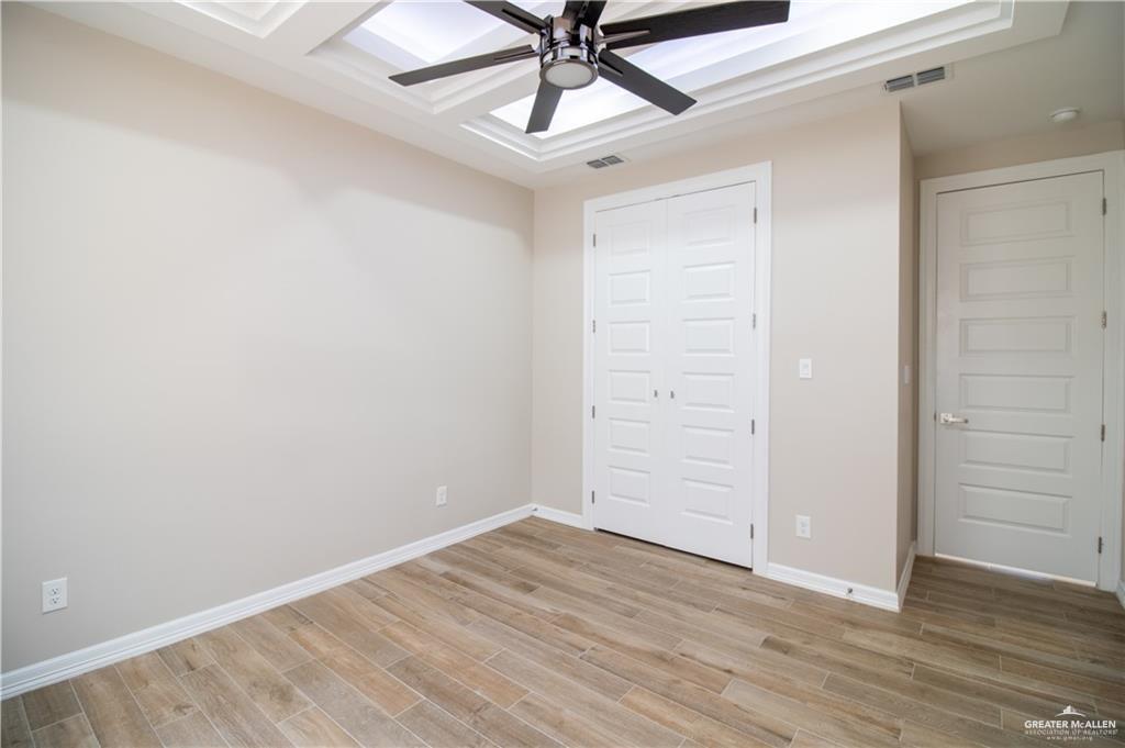 5315 North Crown Point Pharr, TX 78577 - Photo 27 of 30 an empty room with a ceiling fan and wooden floor